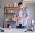Man prepares fresh coffee using a large coffee grinder, ready for brewing.